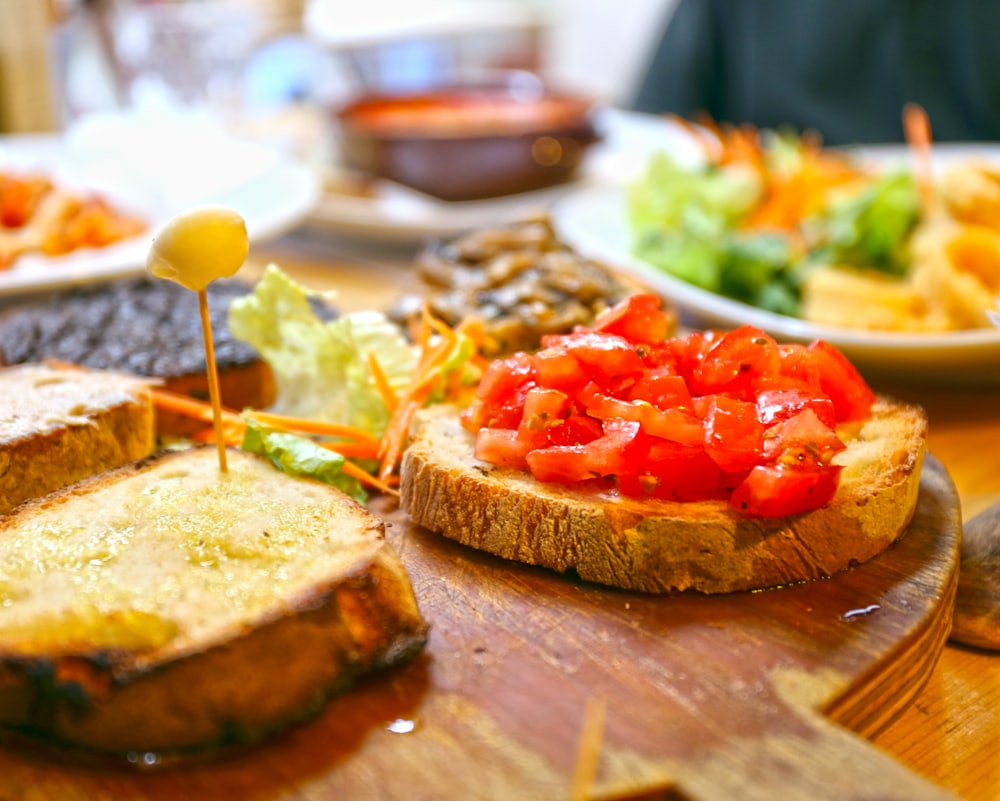 Bread with tomato and vegetables on a wooden table